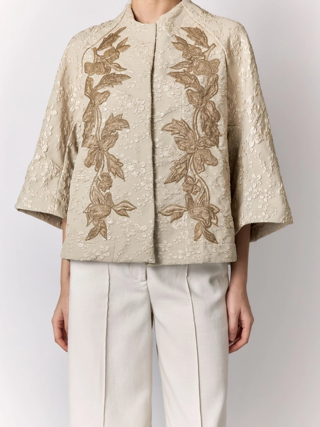 Beige embroidered jacket with floral patterns by Studio Tui on a plain background