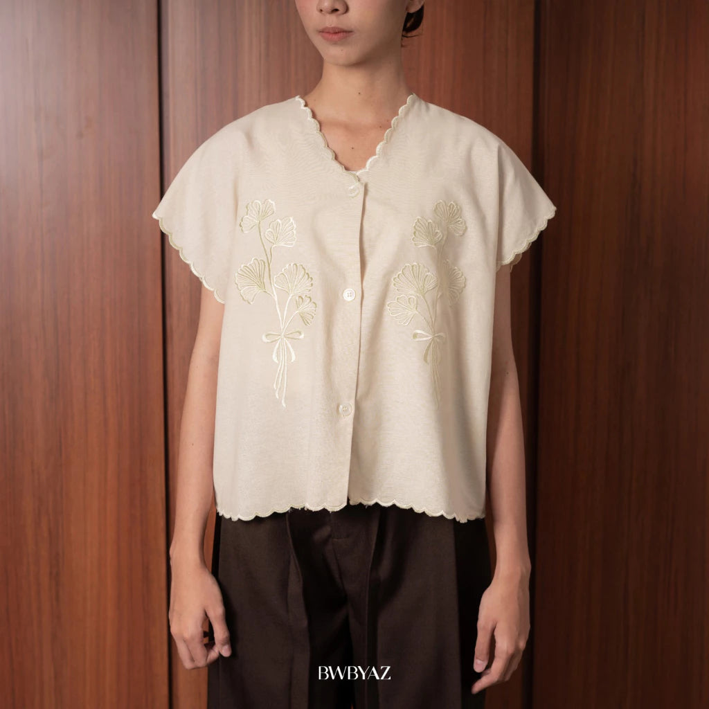 A person wearing a light brown Alaia embroidery tie vest with short sleeves and a v-neck neckline from BWBYAZ.