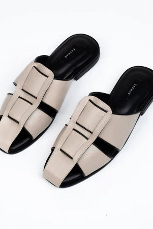 Pair of cream and black mules sandal by Cekhas on a white background