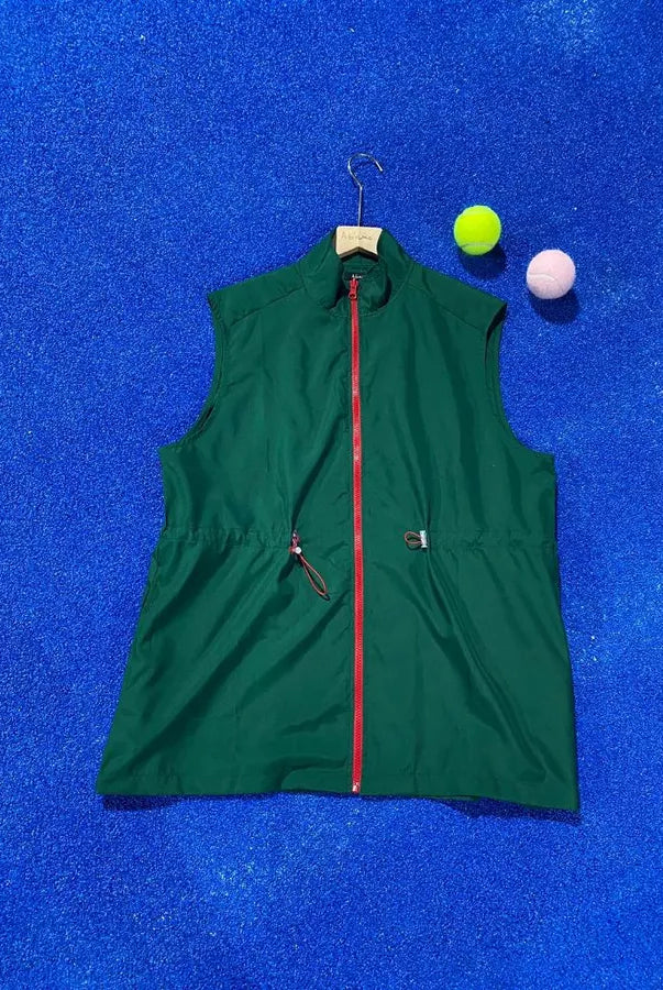 Green vest by Abame with red zipper on a blue textured background