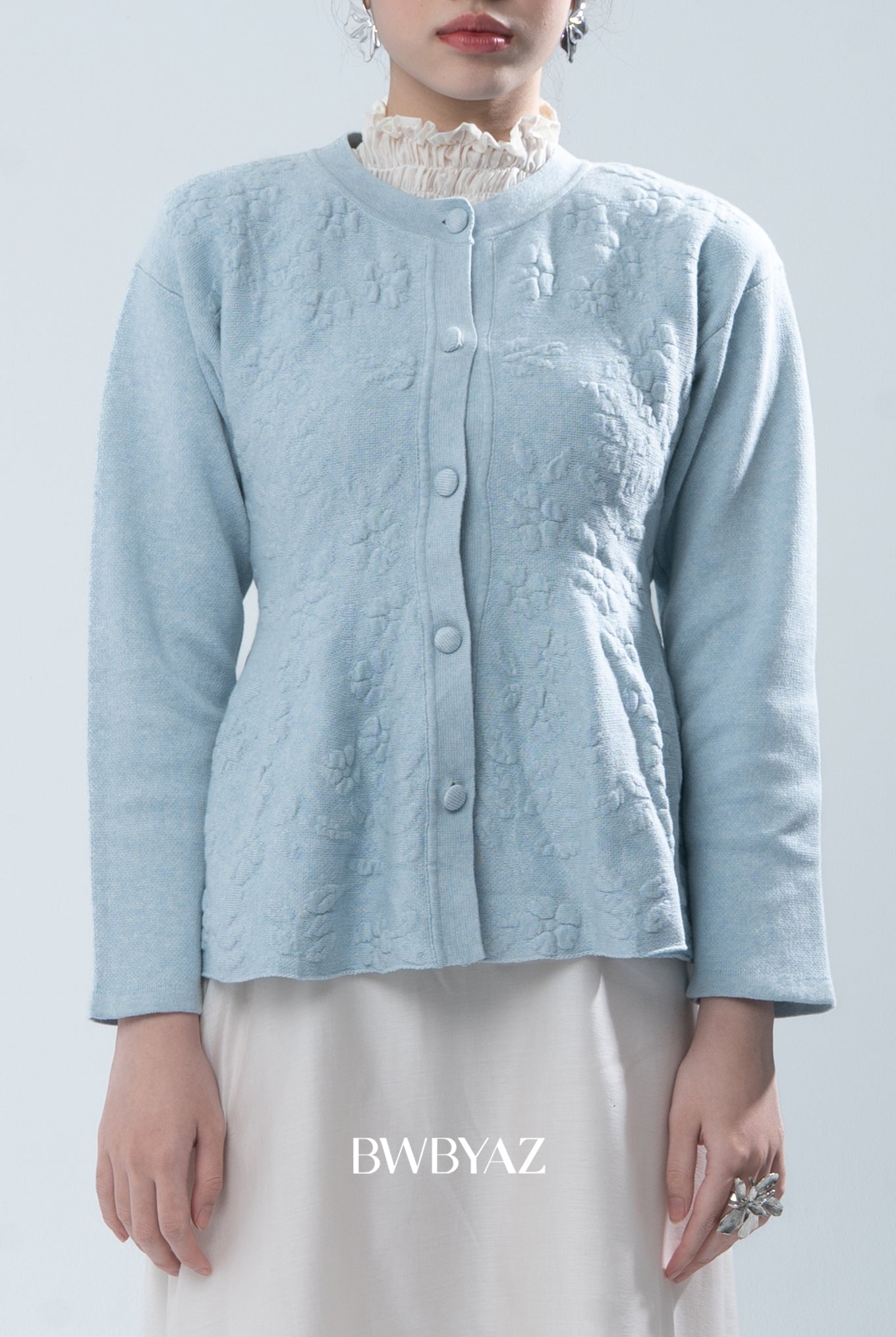 Light blue textured knit cardigan worn by a person on a light gray background, with 'BWBYAZ' branding.