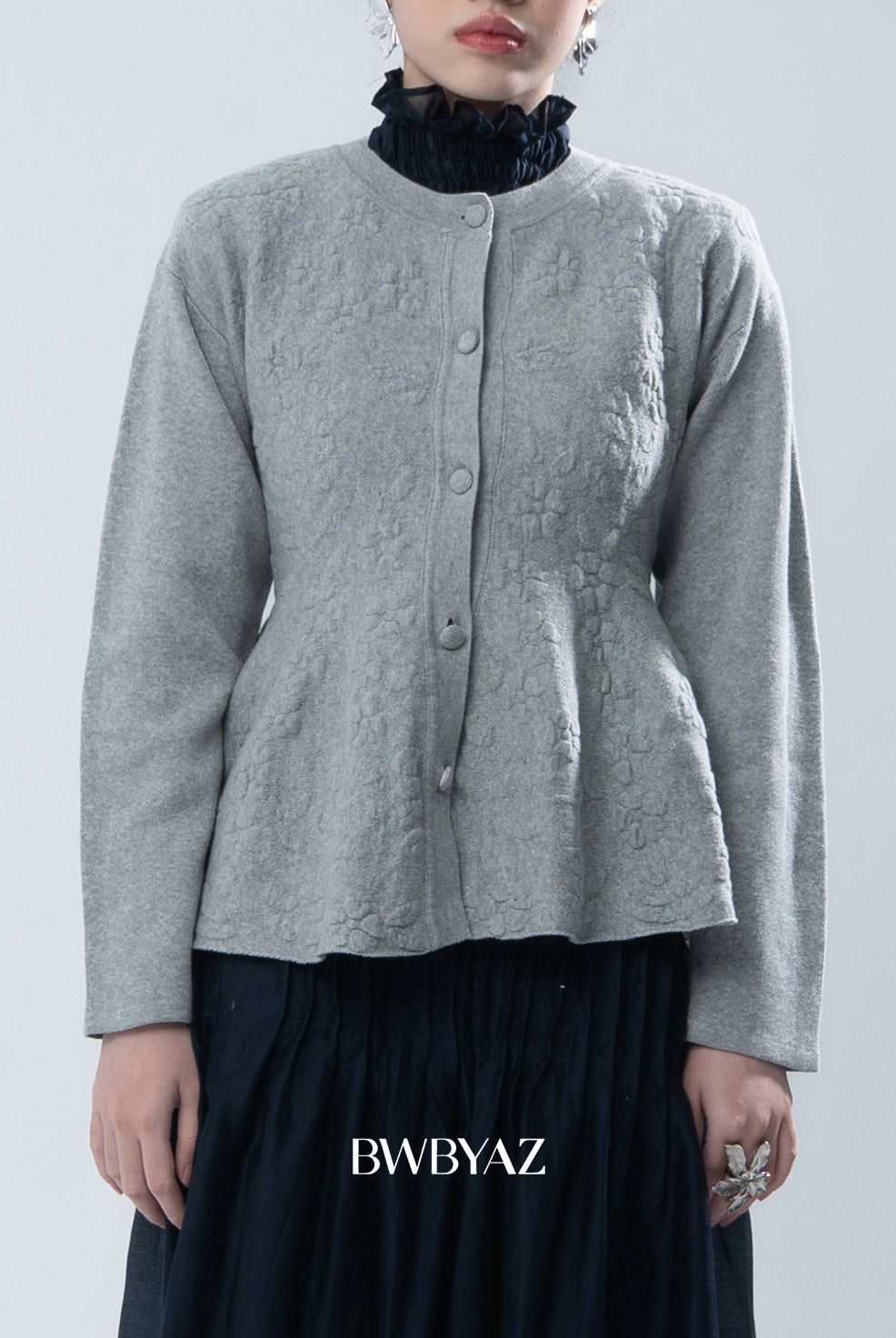 Grey textured knit cardigan worn by a person on a light gray background, with 'BWBYAZ' branding.