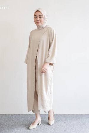 Seorang wanita memakai tunik dan hijab berwarna beige