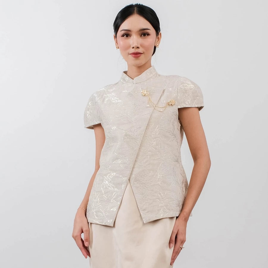 Woman wearing a gold traditional outfit by Holy Peony with a plain background