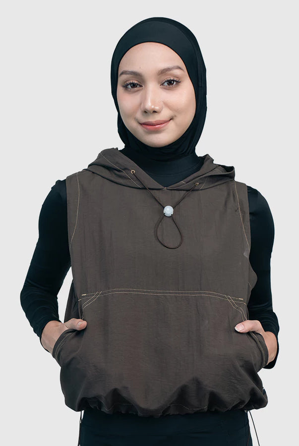 Woman wearing a brown sleeveless vest with a hood by HIA on a white background