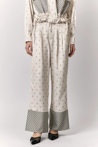 Person wearing a cream-colored outfit with patterned pants by Studio Tui on a white background