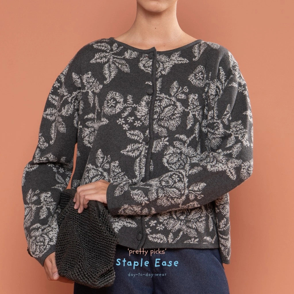 Person wearing a dark floral-patterned cardigan by BWBYAZ against a brown background