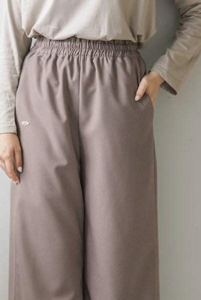 Person wearing latte-colored culotte pants by Mistyvori and a beige long-sleeve shirt against a plain background.
Seorang wanita mengenakan celana kulot berwarna latte dari Mistyvori dan kemeja lengan panjang berwarna beige di depan latar belakang polos.