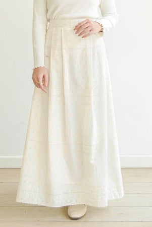 Person wearing a long white skirt by Mistyvori and white top against a light background