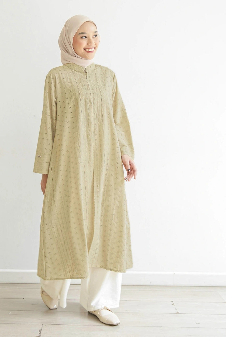Seorang wanita menggunakan Aziza Tunik, tunik berbahan katun embriodery yang busui friendly, berwarna butter dari brand Mistyvori.