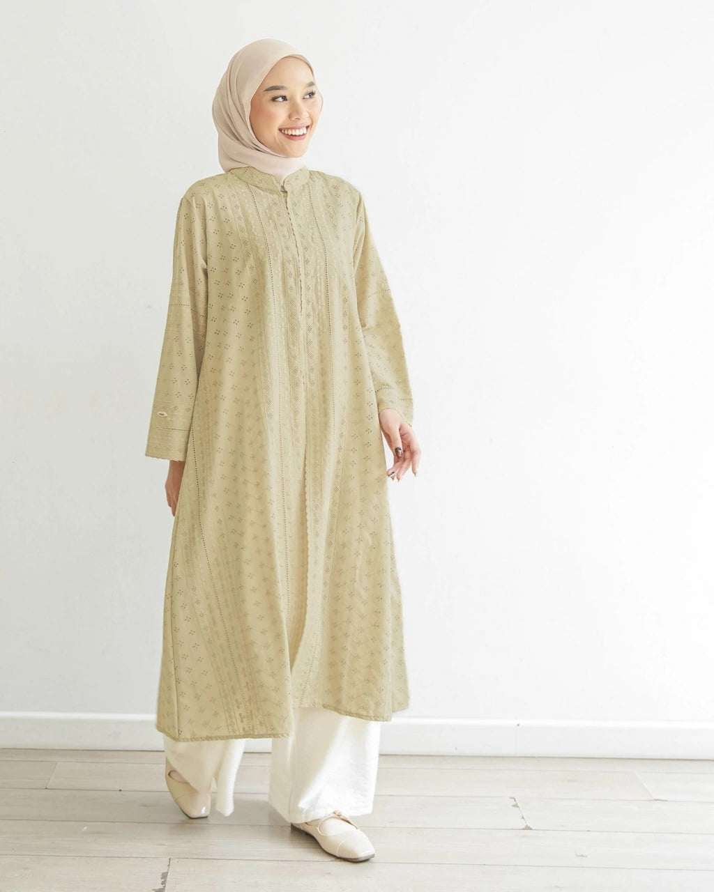 Seorang wanita menggunakan Aziza Tunik, tunik berbahan katun embriodery yang busui friendly, berwarna butter dari brand Mistyvori.
