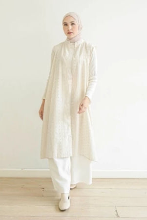 Woman wearing a long white vest by Mistyvori over white inner with a hijab against a white background
