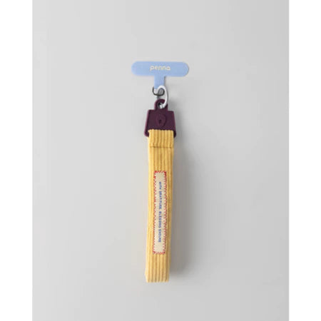 Yellow keychain strap with a dark purple handle from Muhajir Project on a gray background