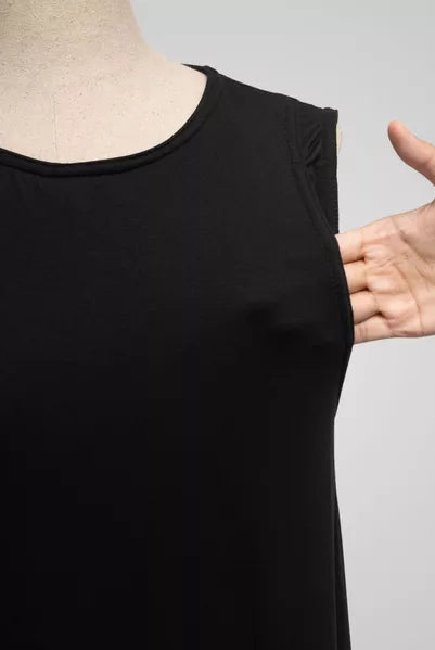 Black sleeveless top on a mannequin with a hand pointing to it, against a gray background
