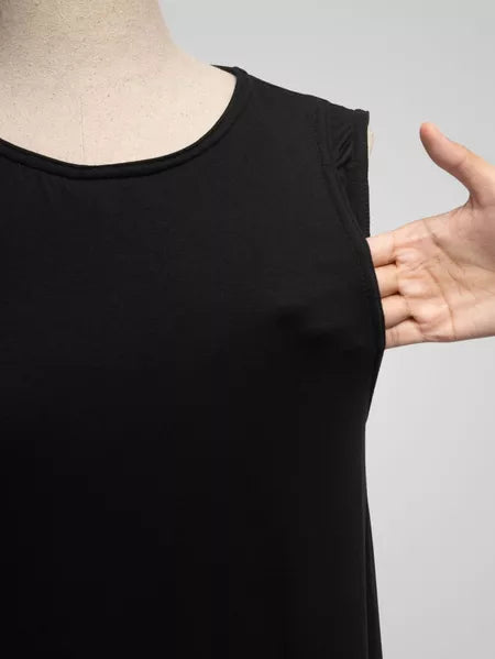 Black sleeveless top on a mannequin with a hand pointing to it, against a gray background