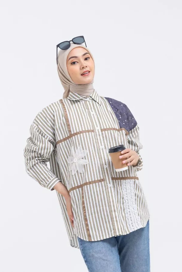 Woman wearing a striped shirt by Abame with brown line accents, holding a coffee cup on a white background