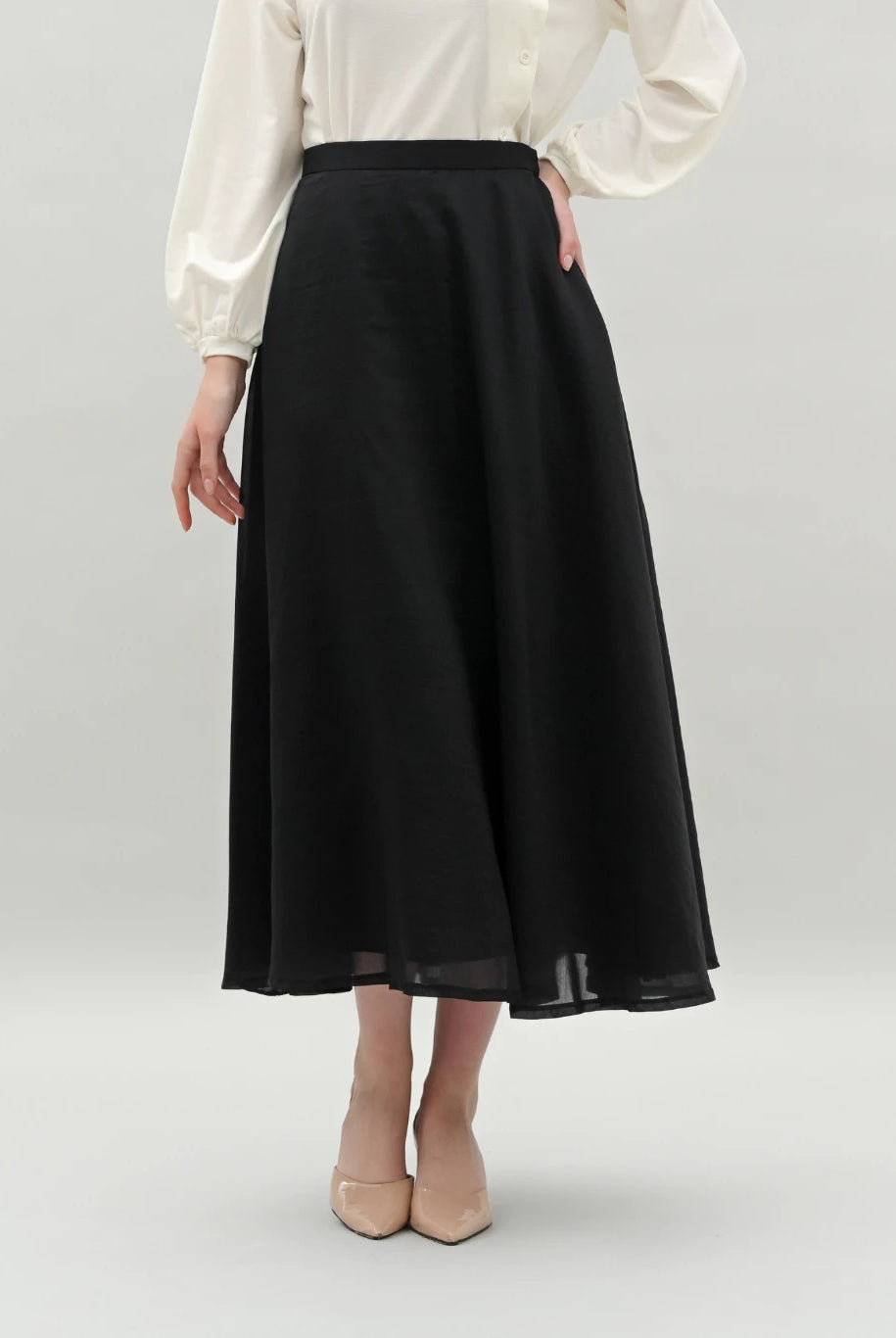 Person wearing a black skirt by Kasa Heritage and white blouse on a plain background