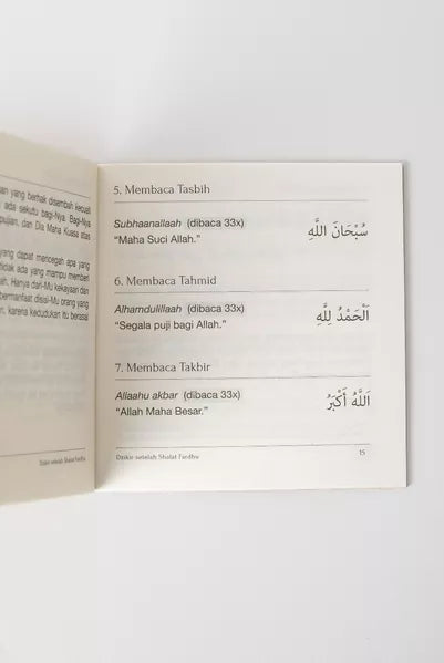 Open book with Arabic text on a white background