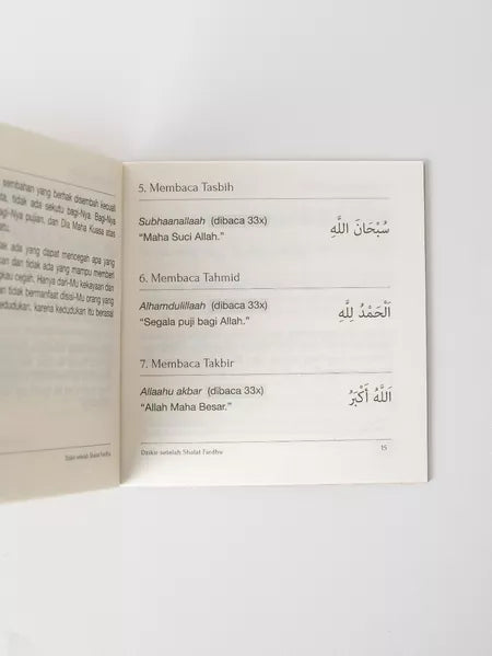 Open book with Arabic text on a white background