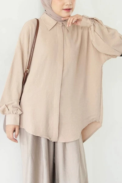 Person wearing a beige shirt by Mistyvori and hijab on a white background