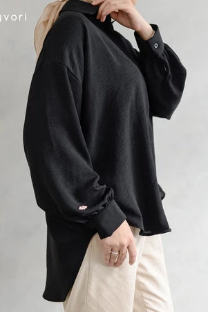 Person wearing a black shirt by Mistyvori with beige pants on a plain background