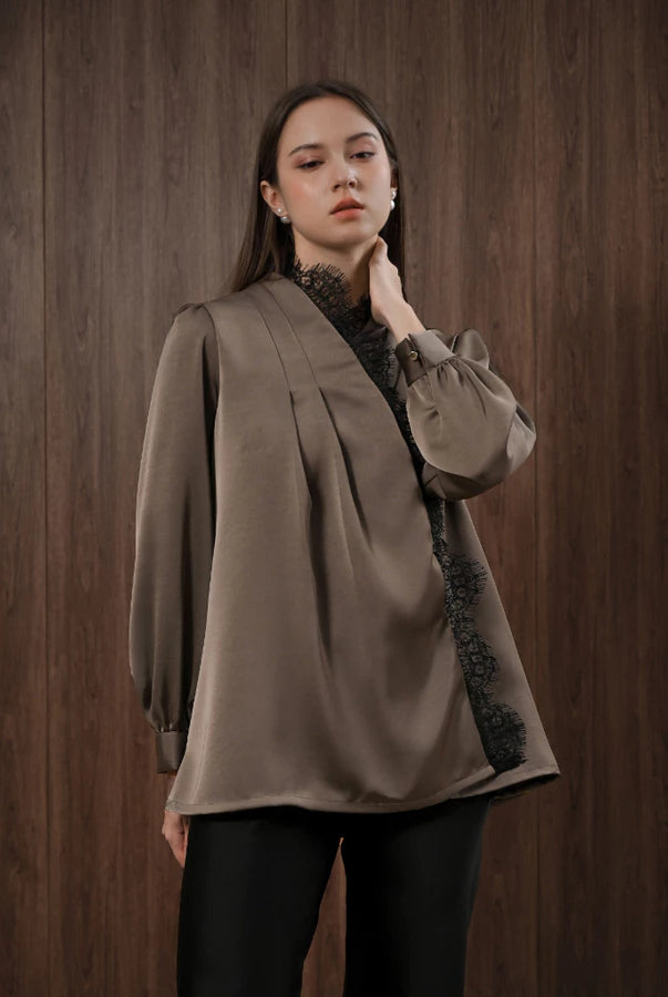 Woman wearing a brown blouse with black lace details by Kasa Heritage against a wooden background