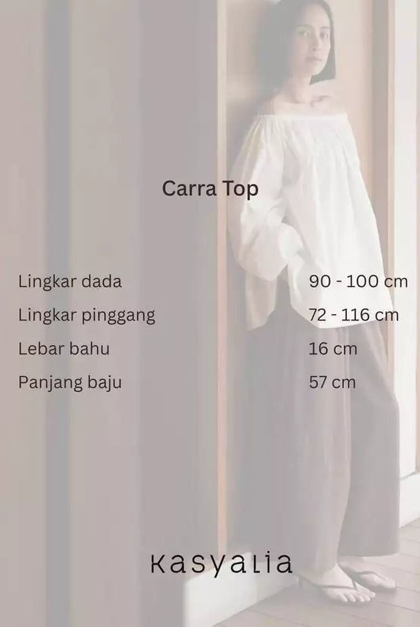 A woman wearing a white off-the-shoulder long-sleeve top and wide-leg pants stands indoors against a light wall, with text overlays showing garment measurements for 'Carra Top' and the brand name 'kasyalia'.