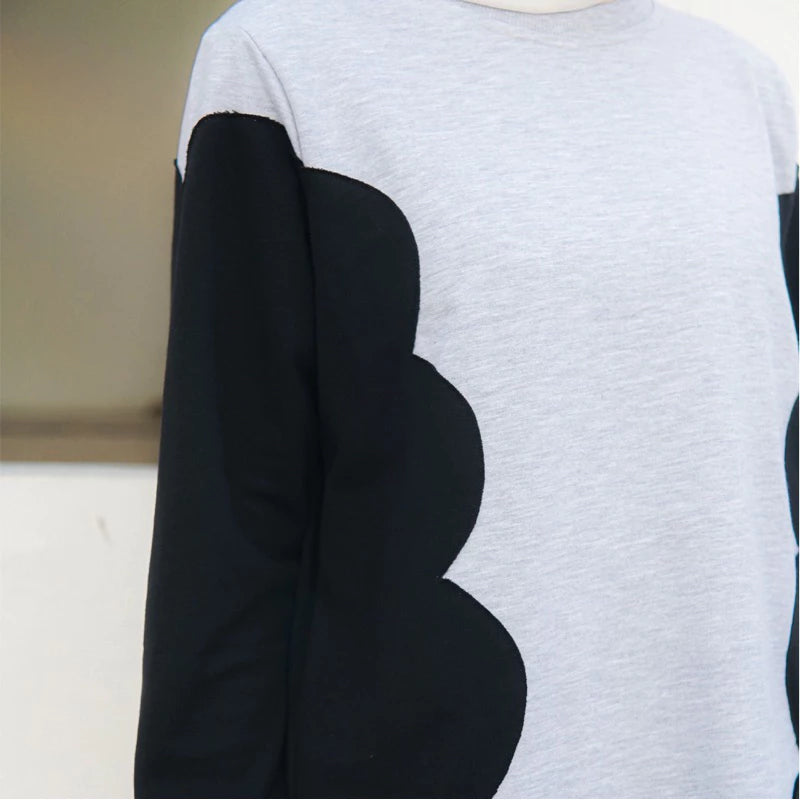 Gray sweater with black scalloped arm designs by Casa Elana on a neutral background