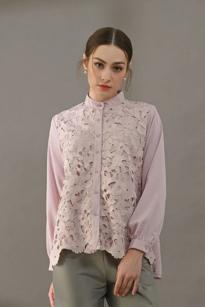 Woman wearing a light pink blouse with lace detailing by Kasa Heritage on a gray background