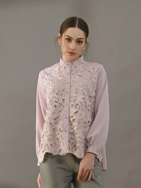 Woman wearing a light pink blouse with lace detailing by Kasa Heritage on a gray background