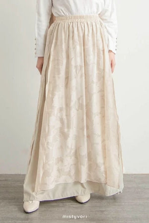 Person wearing a long cream skirt by Mistyvori with a plain background