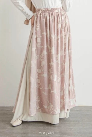Long pink floral skirt by Mistyvori worn with a white top on a plain background
