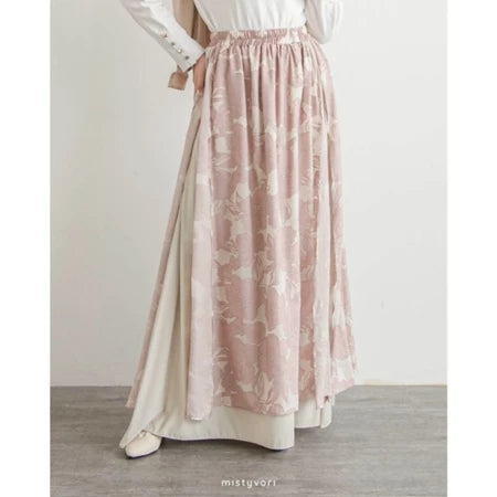 Long pink floral skirt by Mistyvori worn with a white top on a plain background