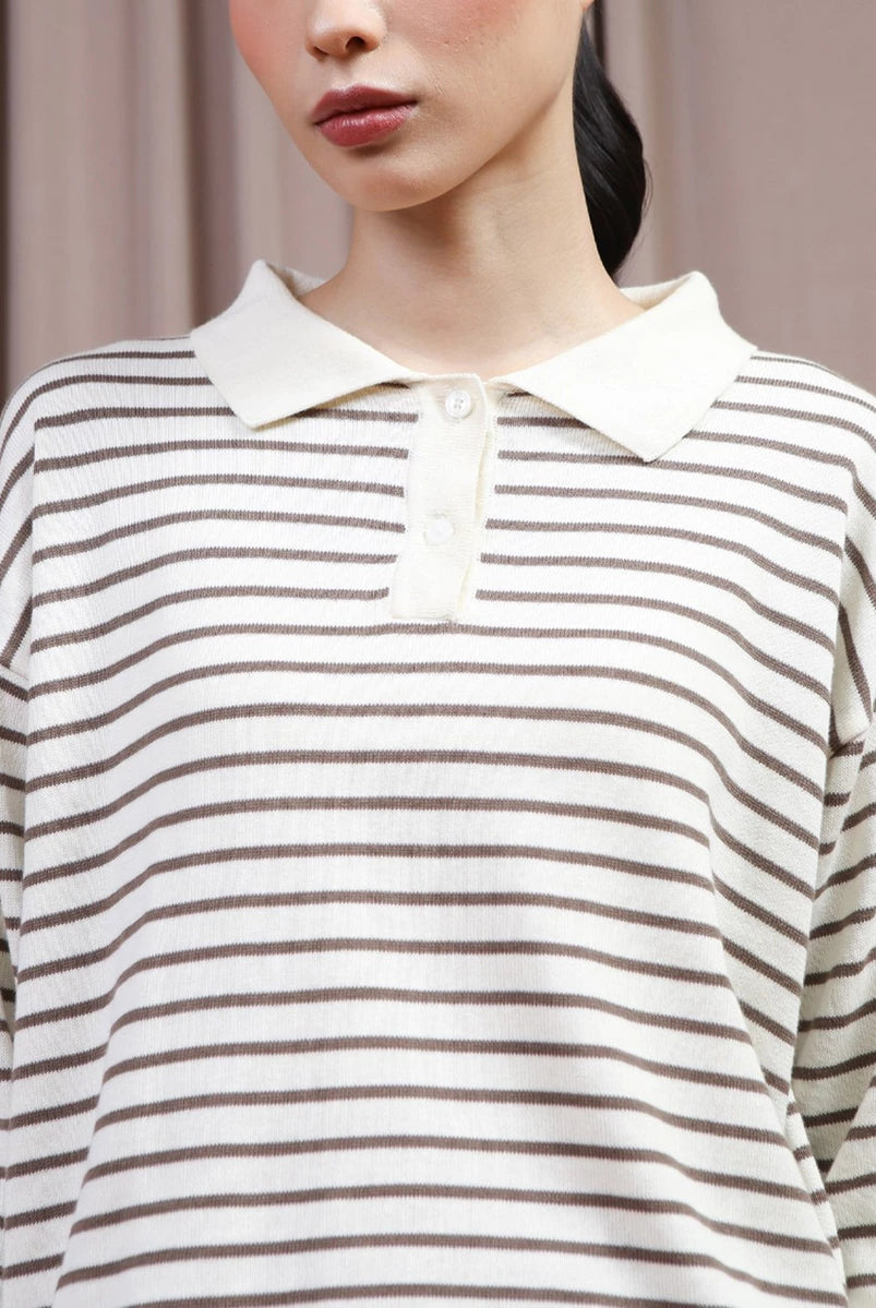 A close-up of a model wearing a long-sleeve polo shirt by Hijabchic with thin brown horizontal stripes on an off-white base, featuring an off-white collar and a three-button placket.