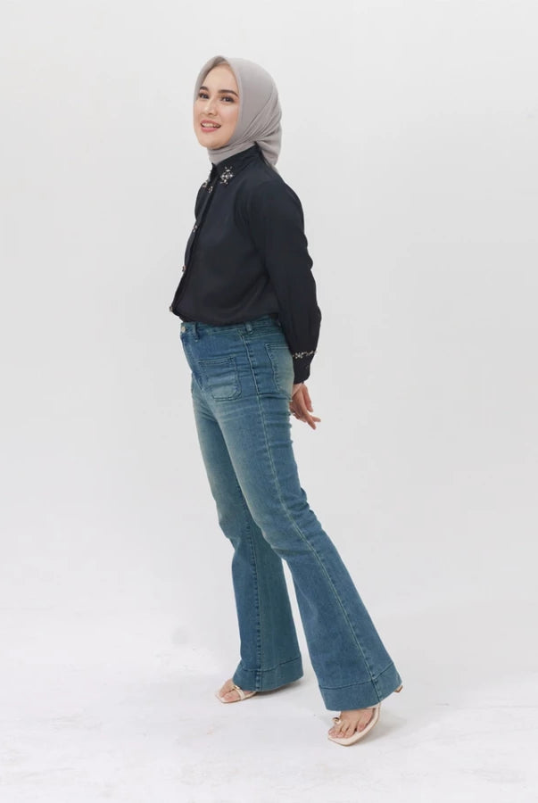 Woman wearing a black top and blue flared denim pants by Jenna & Kaia on a white background
Seorang wanita yang mengenakan atasan hitam dan celana denim berpotongan melebar berwarna biru dari Jenna & Kaia, dengan latar belakang putih