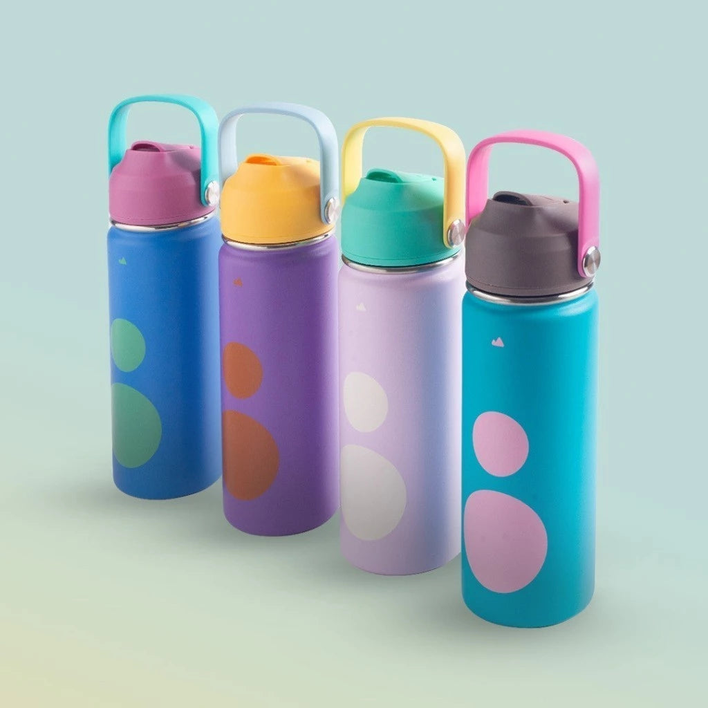Four colorful water bottles with polka dot designs on a light green background