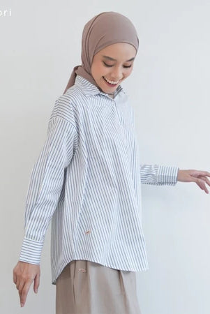 Woman wearing a blue striped shirt by Mistyvori and hijab on a plain background