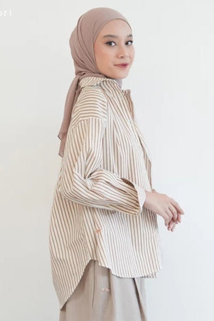 Woman wearing a cream striped shirt by Mistyvori and hijab on a white background