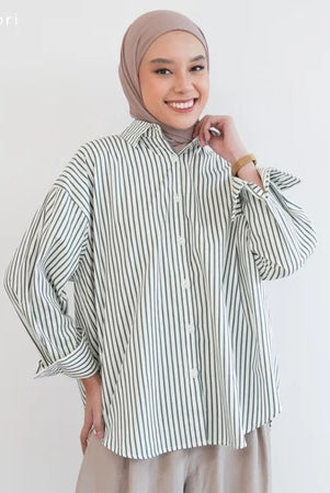 Woman wearing a green striped shirt by Mistyvori and hijab on a plain background