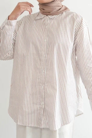 Person wearing a light brown striped shirt by Mistyvori and hijab on a white background