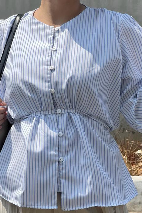 Person wearing a blue striped blouse by BWBYAZ holding a glass against a plain background