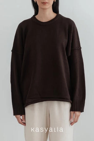 Person wearing a dark brown oversized sweater and beige pants on a light gray background with 'kasyalia' branding.