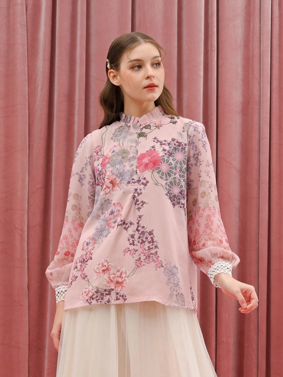 Woman wearing a floral pink blouse by Kasa Heritage against a pink curtain background