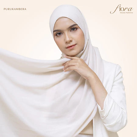 A woman wearing a broken white pashmina viscose draped around her head, with the brand 'Puru Kambera' visible on the scarf.
