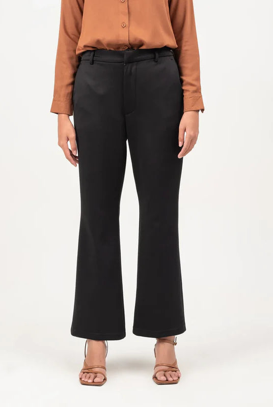 Person wearing a brown button-up shirt and black flare pants from Atala Scarves on a white background