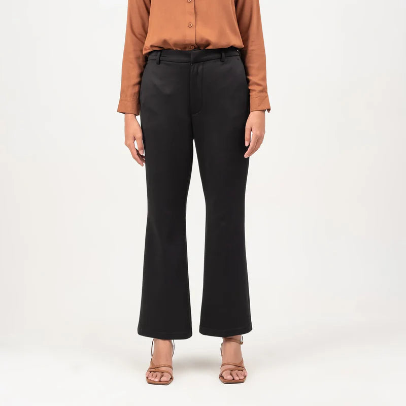 Person wearing a brown button-up shirt and black flare pants from Atala Scarves on a white background