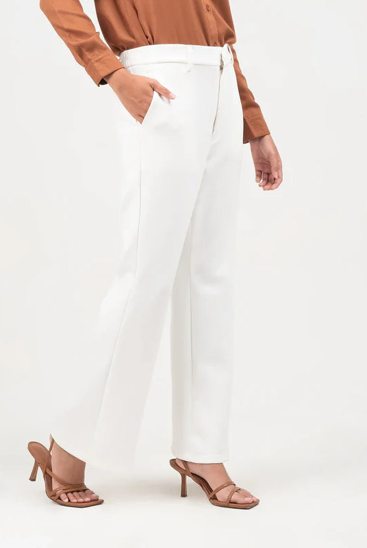 Person wearing a brown top and white flare pants from Atala Scarves on a white background