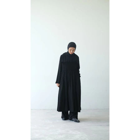 Person wearing a long black dress and black headscarf by Rashawl on a white background