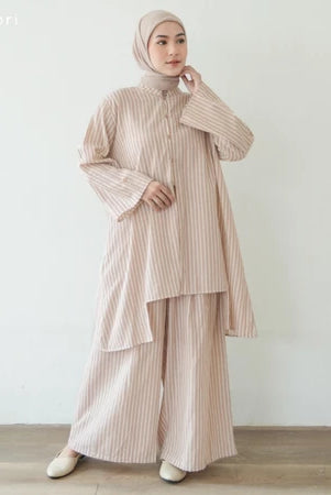 Woman wearing a light brown outfit set by Mistyvori with a hijab against a white background