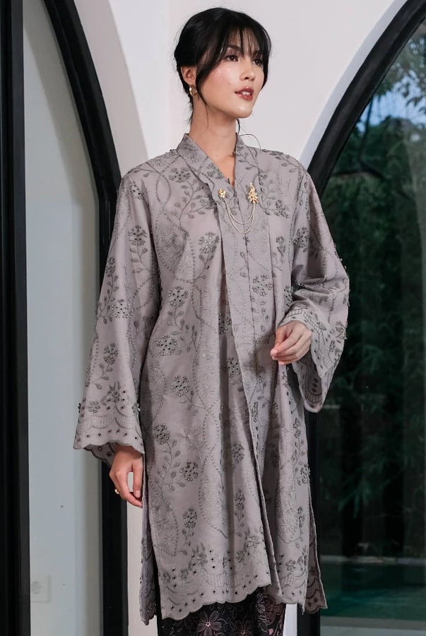Woman wearing a gray women’s tunic by Holy Peony with subtle floral patterns, a loose silhouette, and wide sleeves. The tunic features a layered front detail and above-the-knee length, creating an elegant and flowy look.
Wanita mengenakan tunik wanita warna abu-abu dari Holy Peony dengan motif floral halus, potongan longgar, dan lengan lebar. Tunik memiliki detail layering di bagian depan dengan panjang di atas lutut, menciptakan tampilan elegan dan flowy.